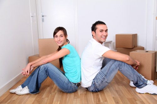 Removalists placing furniture and boxes into rooms after delivery